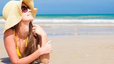 Frau mit Sonnenhut sonnt sich. 