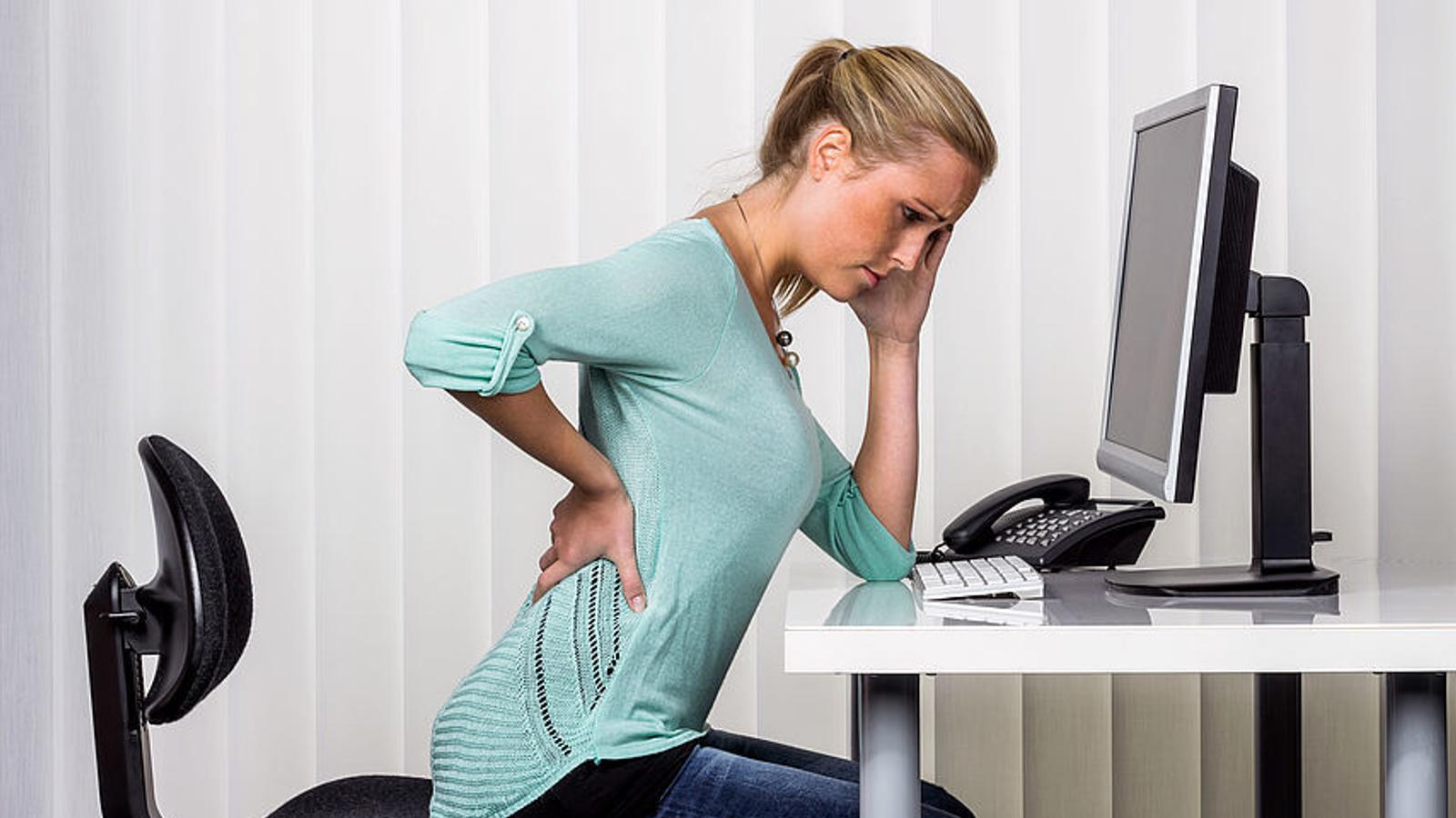 Frau hat Schmerzen im Rücken - ein möglicher Bandscheibenvorfall