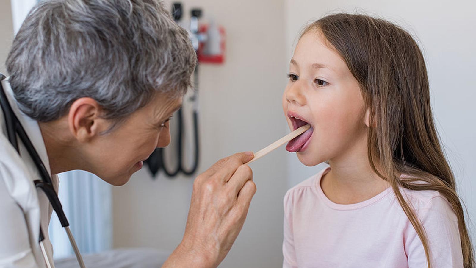 Ärztin untersucht Mädchen auf Angina