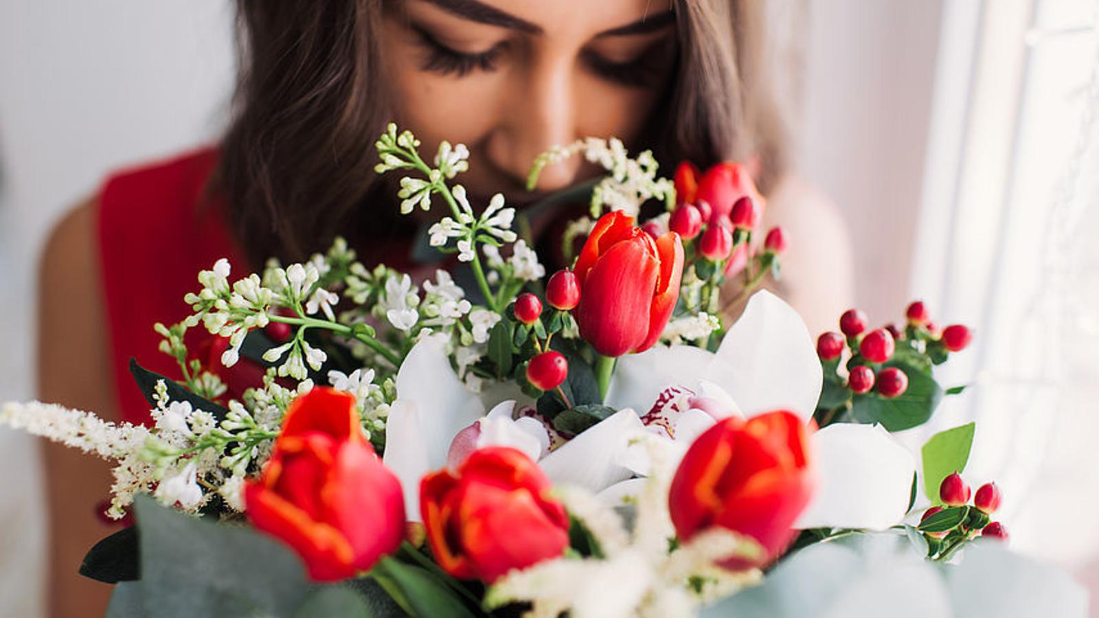 Frau riecht an einem Blumenstrauß