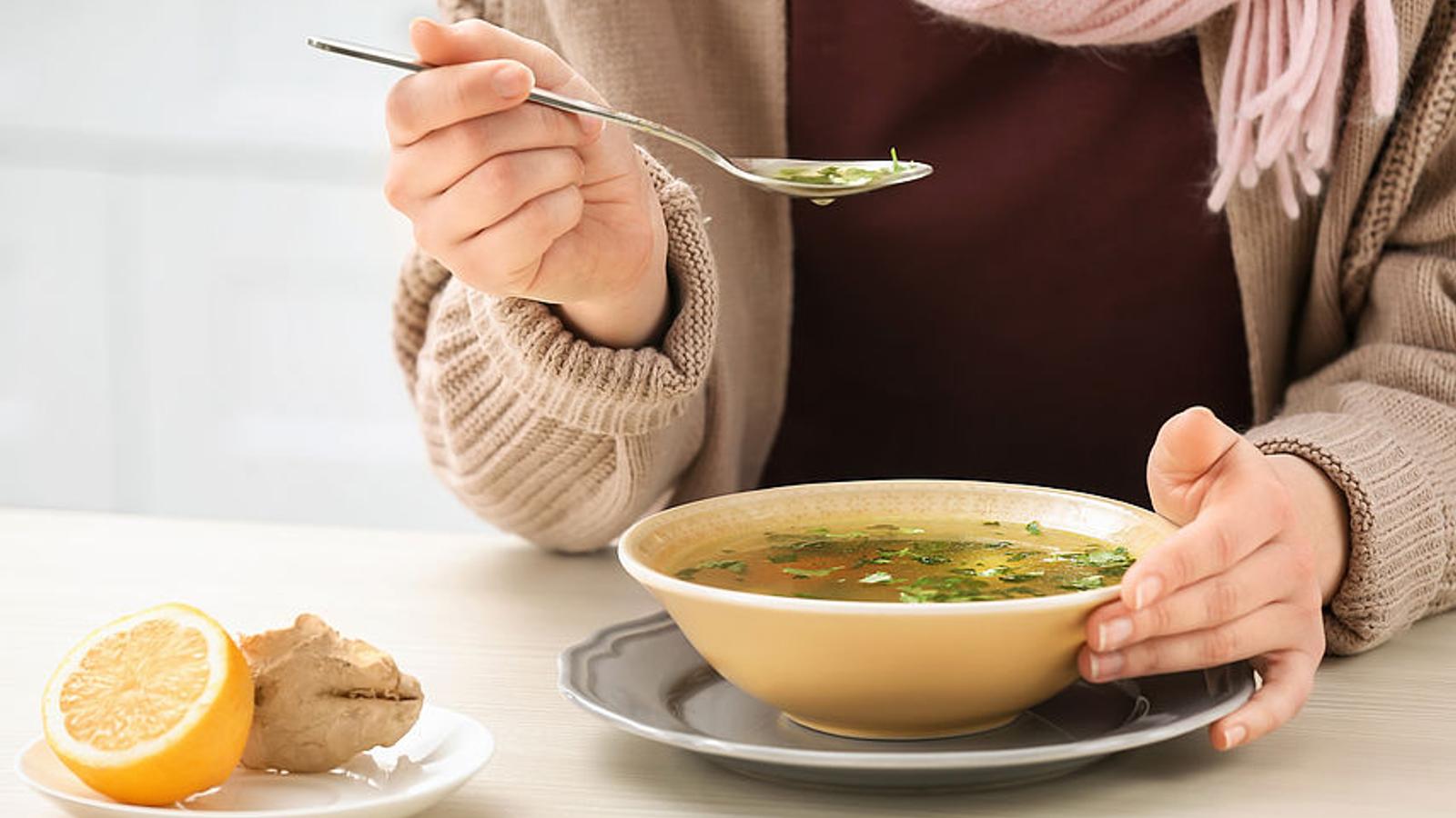 Erkältete Frau isst Hühnersuppe.