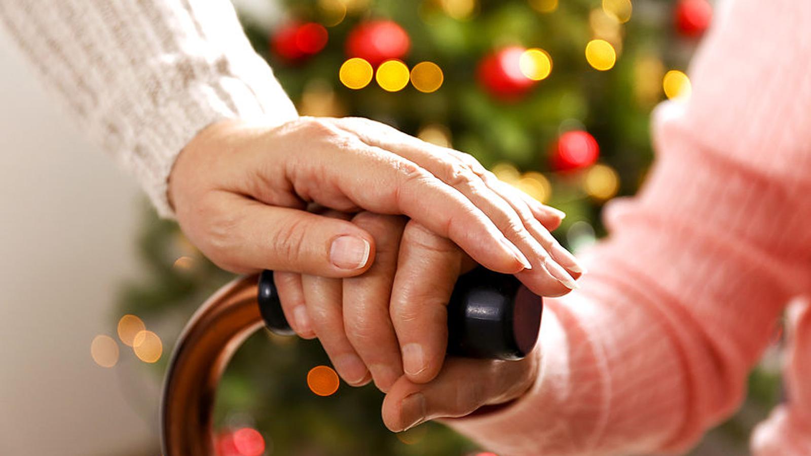 Frau hält Hand von Dame mit Stock