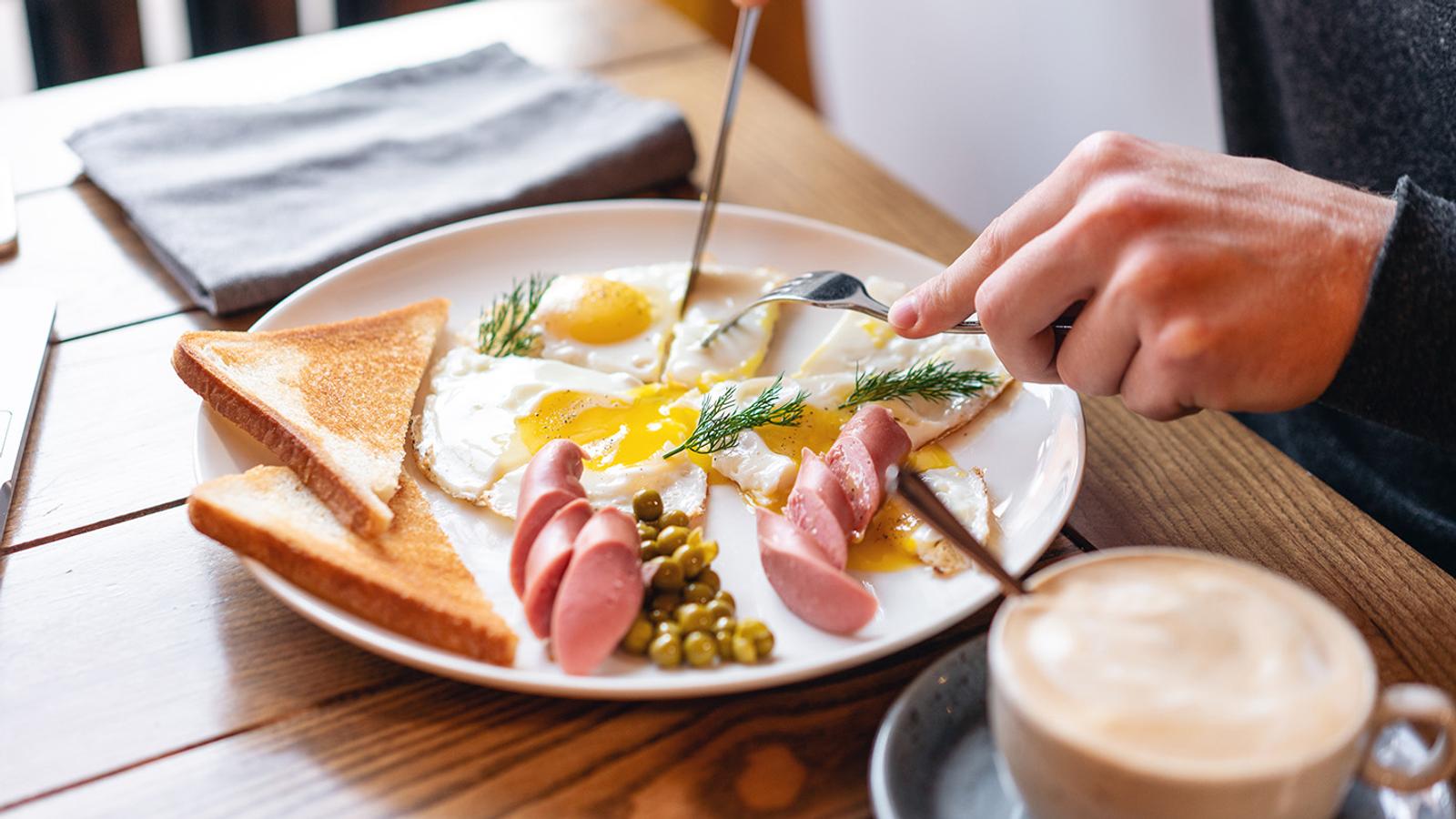 Spiegelei Würstchen und Kaffee stehen am Frühstückstisch