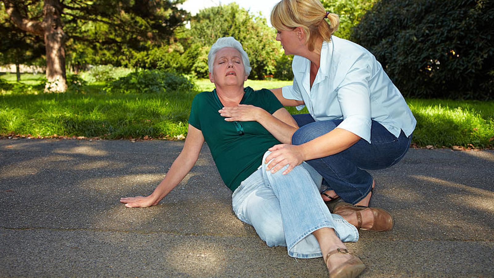 Frau hilft einer älteren Dame, die einen Lungeninfarkt erleidet