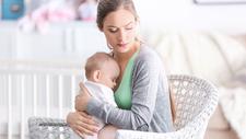Mutter mit postpartaler Depression hält ihr Baby im Arm
