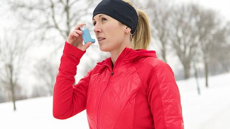 Läuferin mit Inhalator in einer Winterlandschaft