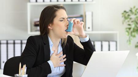 Frau hat einen Asthmaanfall im Büro