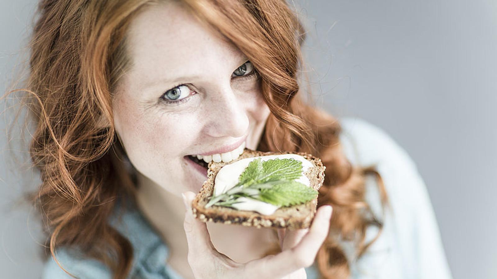 Frau beißt in ein Vollkornbrot