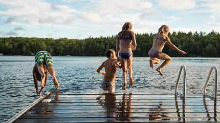 Kinder springen in natürliches Gewässer