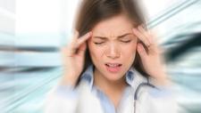 Frau hat starke Kopfschmerzen – der Hintergrund ist unscharf