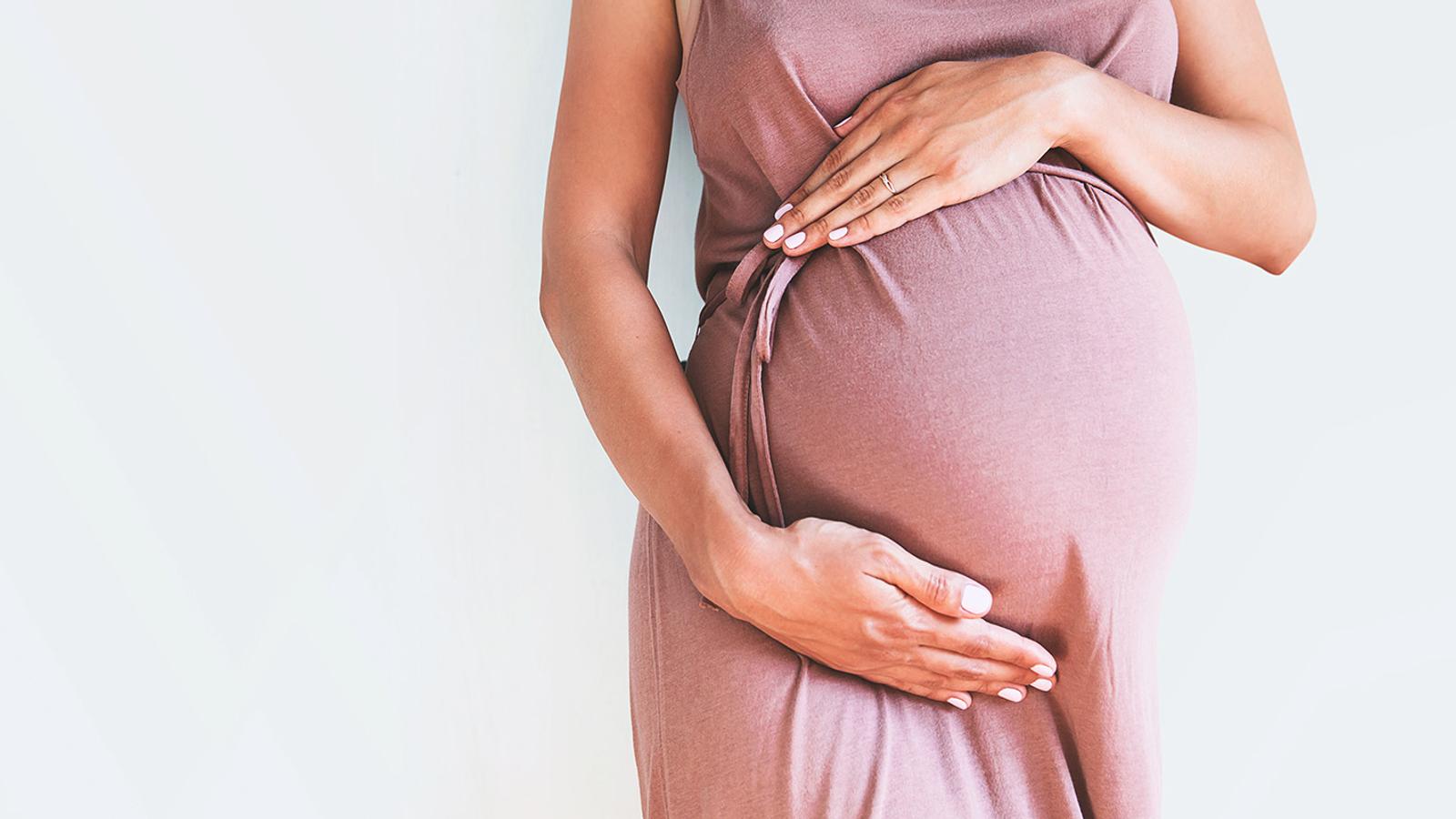 Schwangerschaft und Geburt Schwangere Frau hält ihren Babybauch
