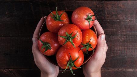 Frau hält Tomaten in den Händen
