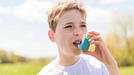 Junger Asthmatiker verwendet Asthma-Spray
