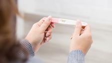 Frau hält Schwangerschaftstest in den Händen