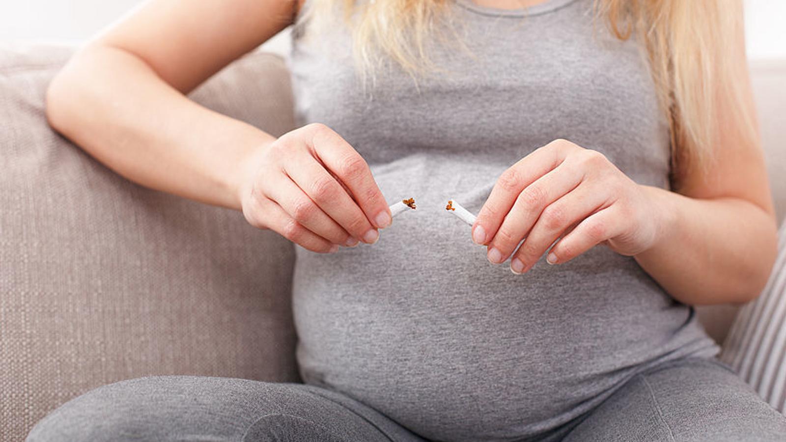 Schwangere Frau zerbricht ihre Zigarette