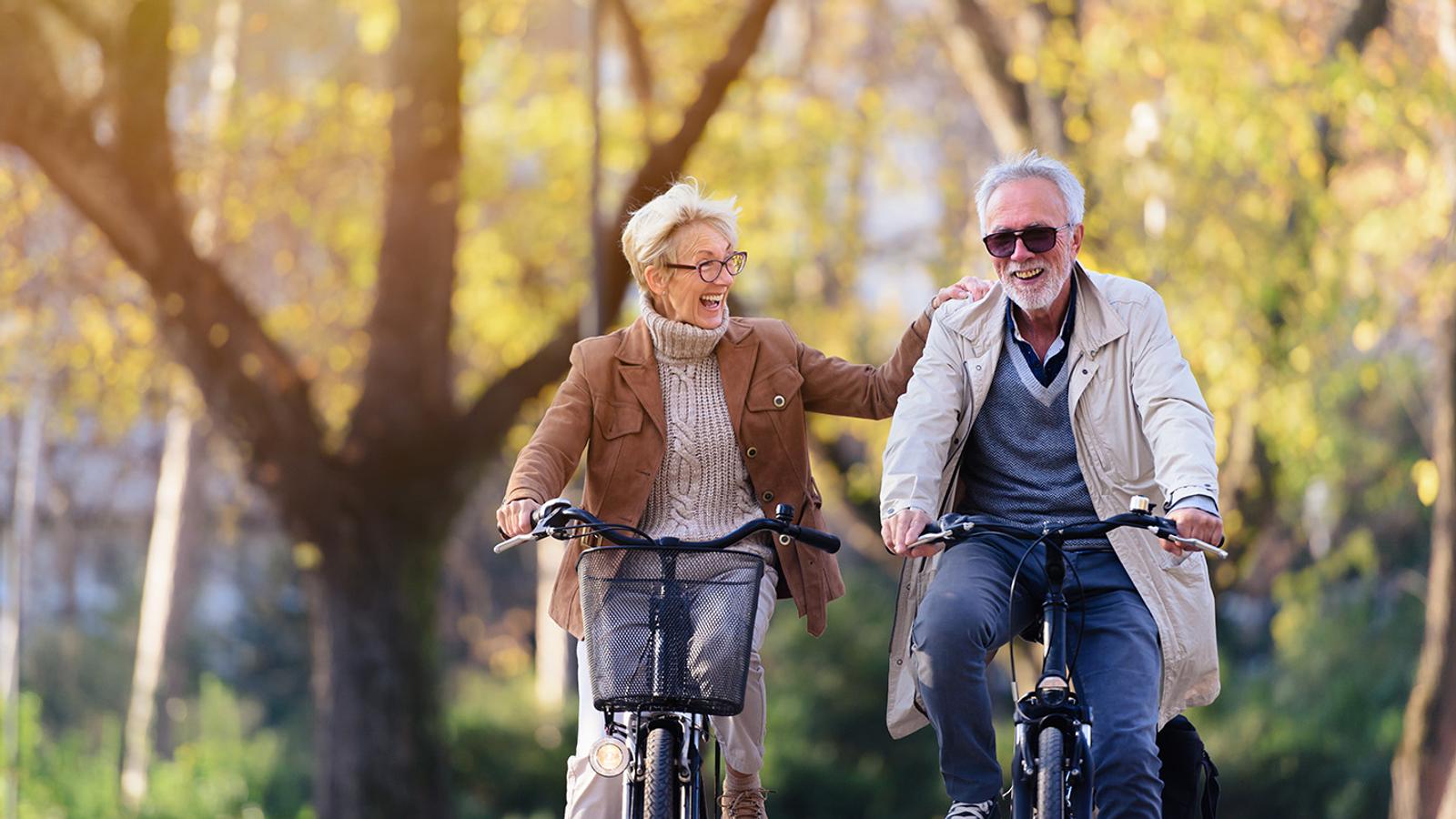 Älteres Pärchen mit Rheuma hat Freude beim Radfahren