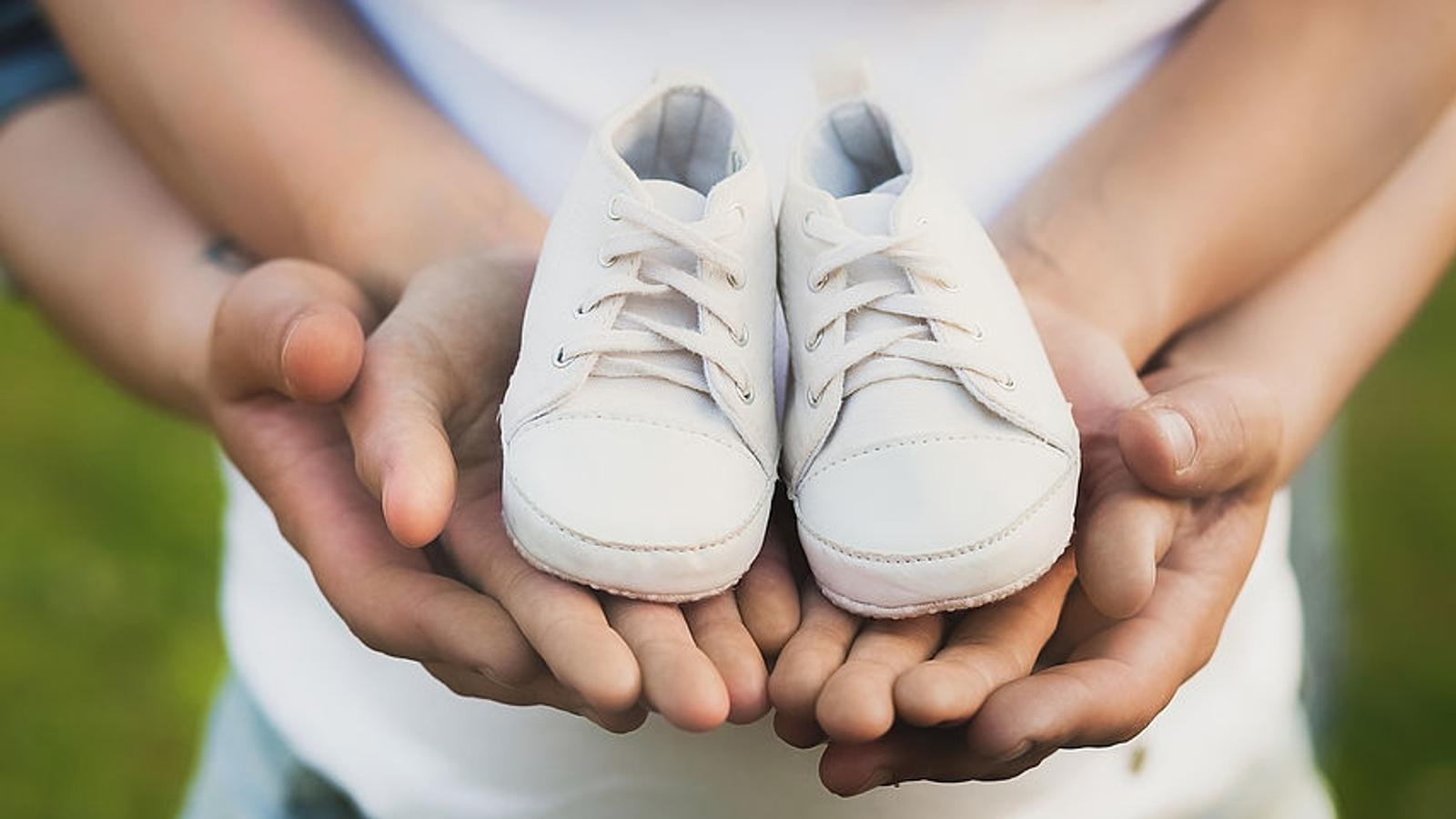 Paar hält Babyschuhe in der Hand