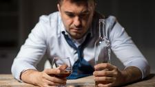 Mann mit Alkoholproblem sitzt vor einem Glas Wein