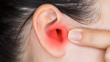 Frau mit Gehörgangsentzündung hat Ohrenschmerzen