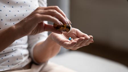 Frau nimmt Tabletten als Therapie