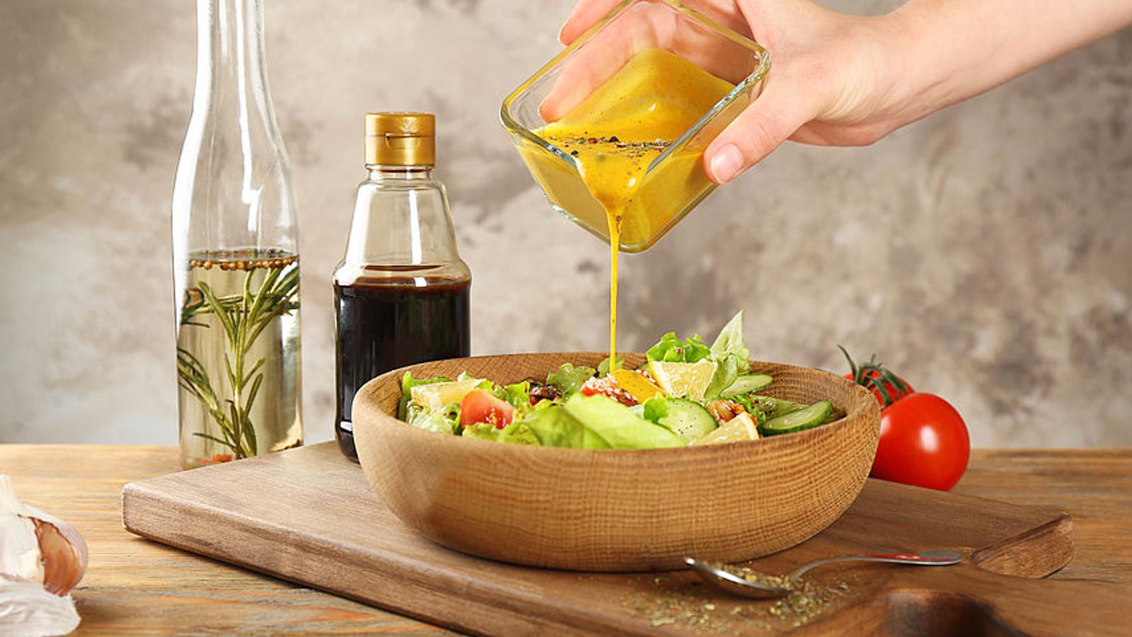 Frau kippt Dressing auf ihren Salat.