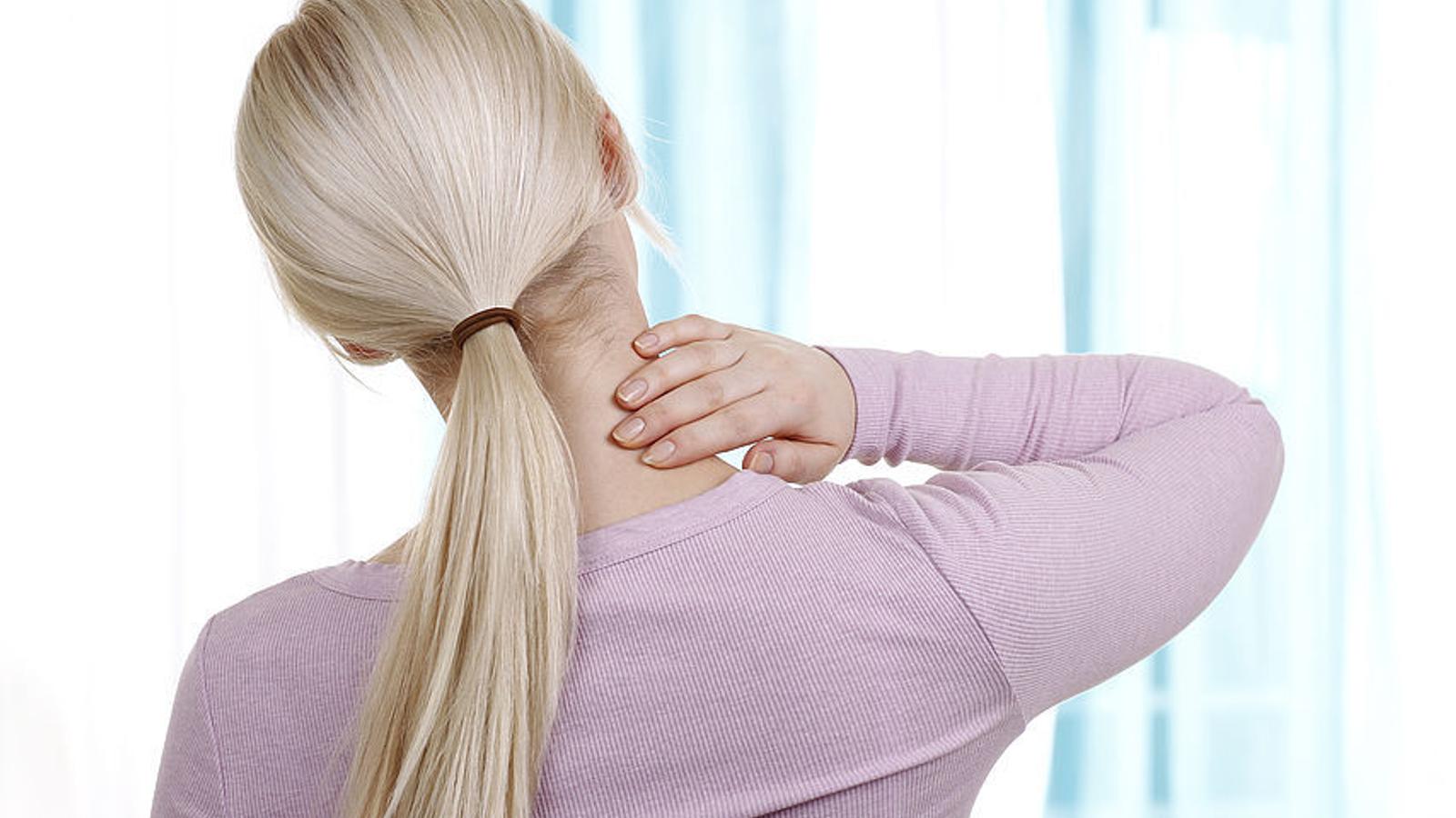 Frau mit Zervikalsyndrom greift sich auf den Nacken