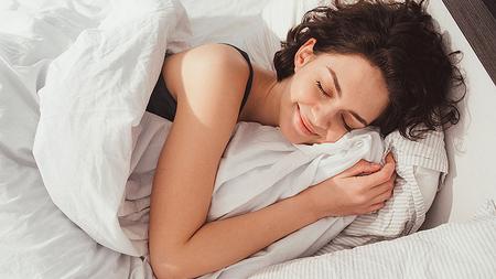 Frau mit gutem Schlafrhythmus schläft im Bett