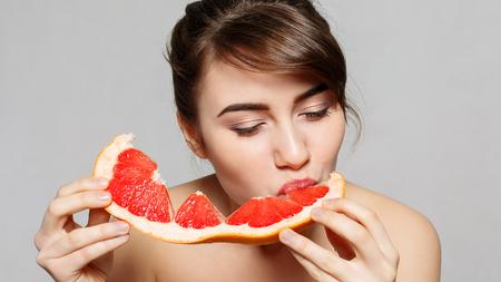 Frau mit Antibabypille isst Grapefruit