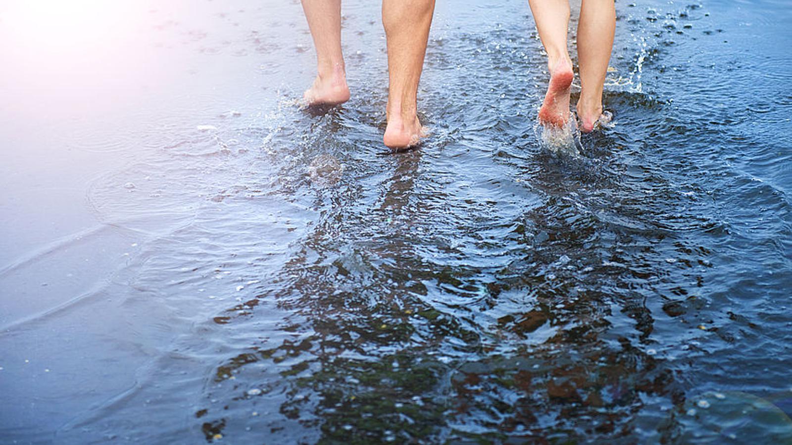 Kneipp-Medizin: Zwei Menschen gehen barfuß durchs Wasser