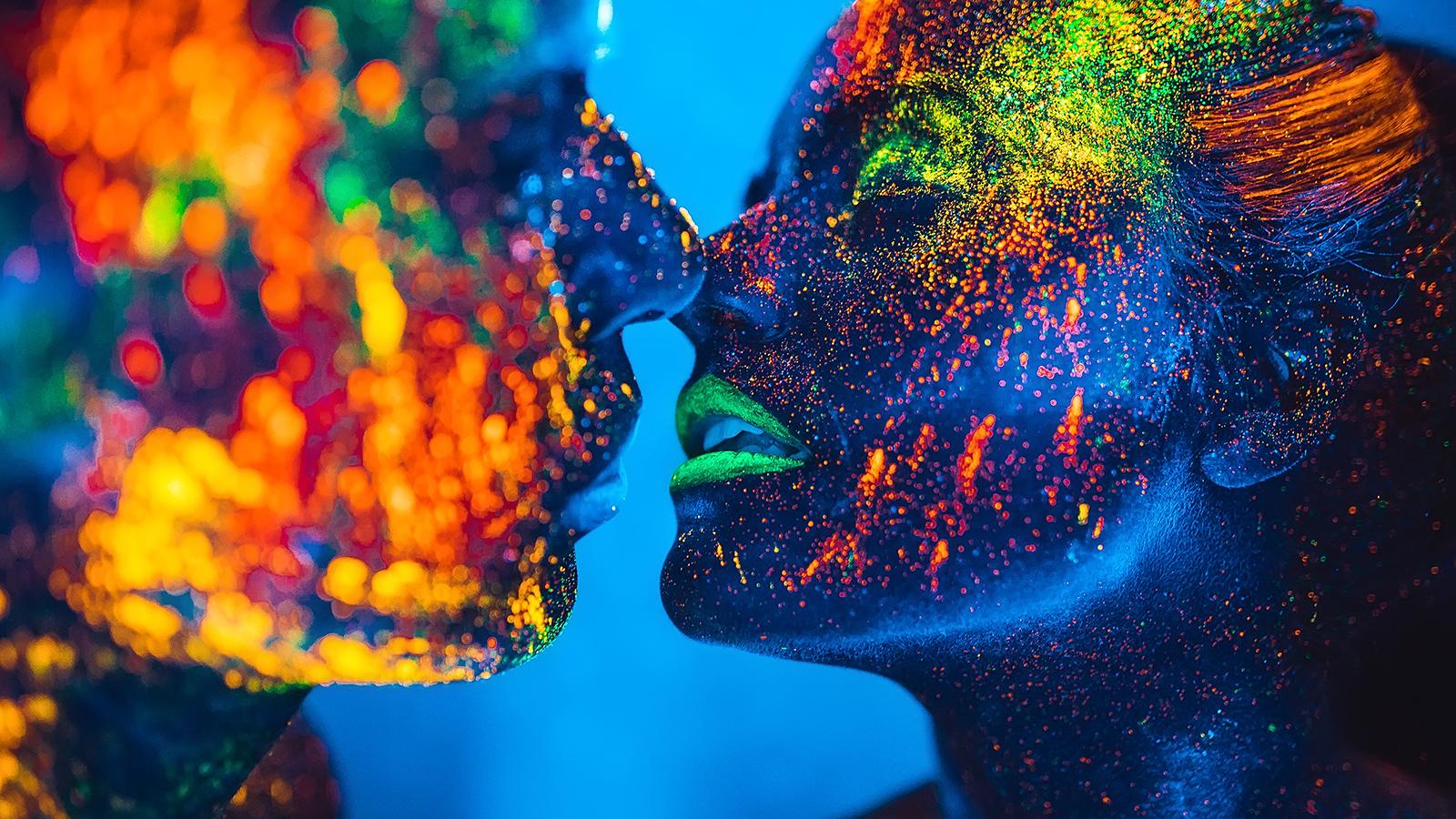 Ein Liebespaar küsst sich – mit fluoreszierendem Pulver bestäubt