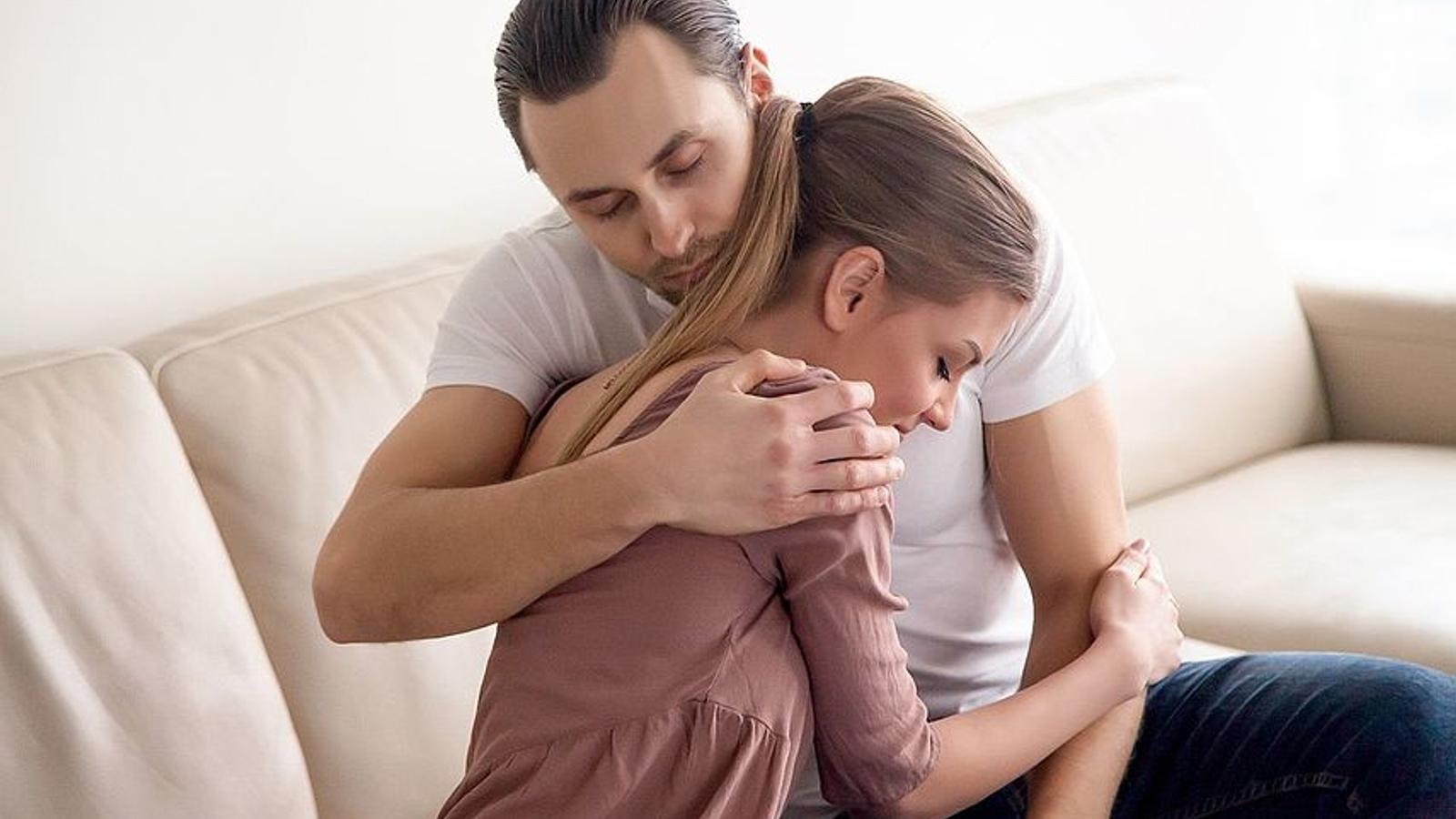 Mann und Frau trösten sich gegenseitig, um Tief wegen unerfülltem Kinderwunsch zu bewältigen