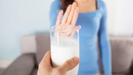 Frau lehnt Glas Milch ab