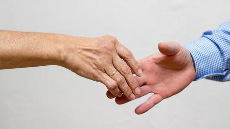 Zwei Personen geben sich die Hand. 