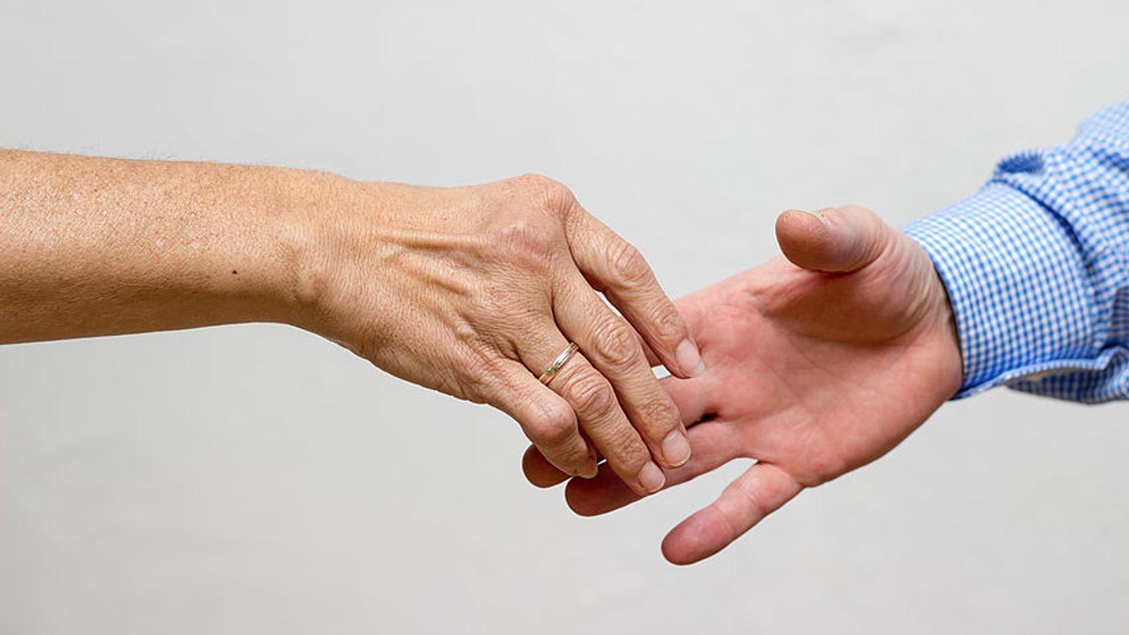 Zwei Personen geben sich die Hand. 