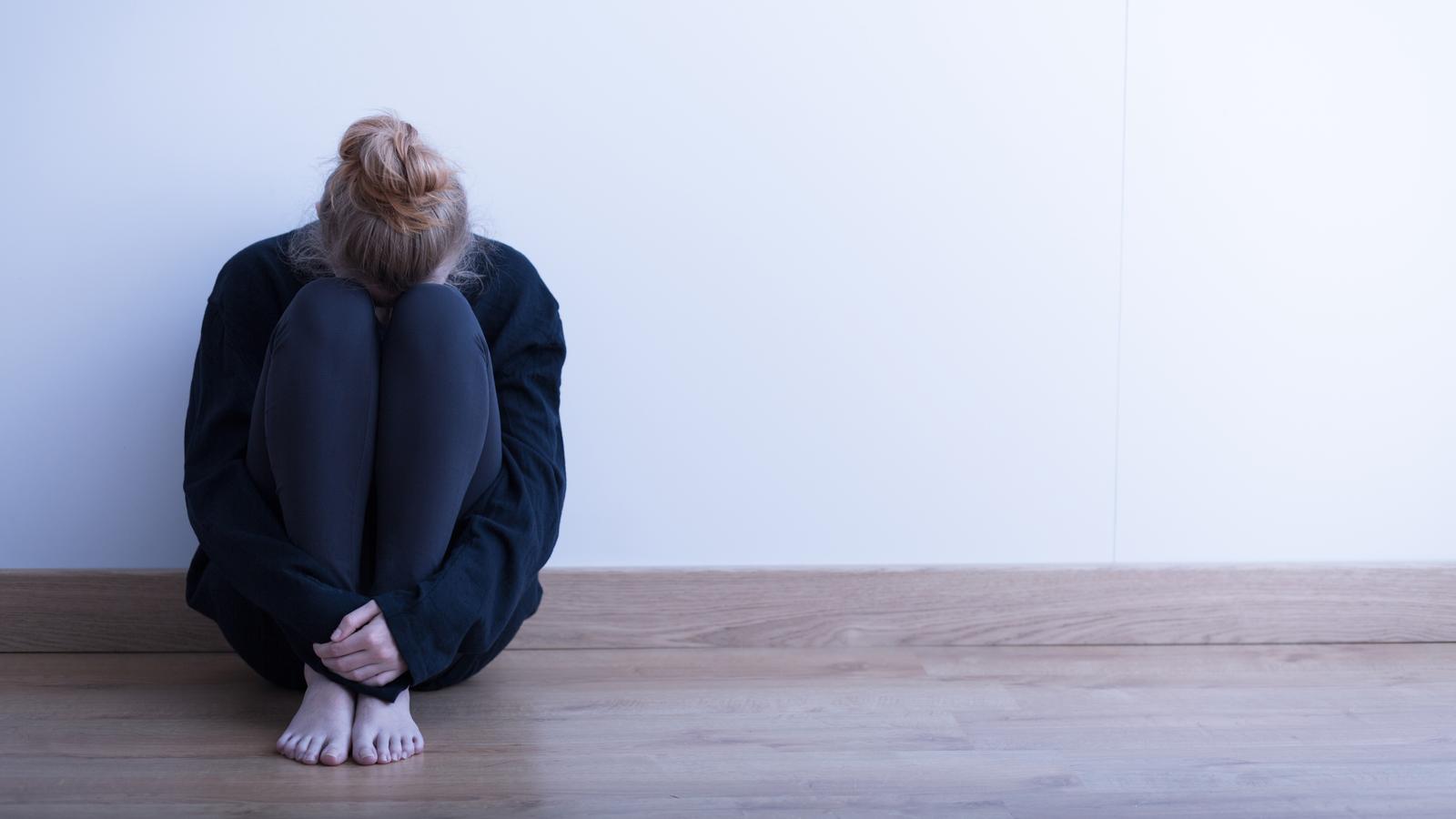 Frau mit Angststörung sitzt am Boden