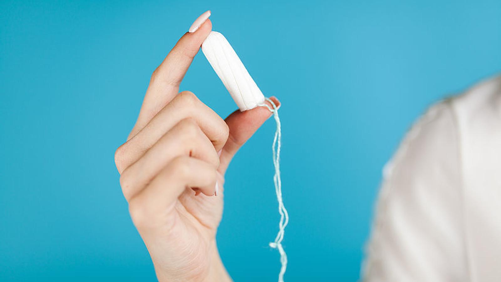 Frau hält Tampon in der Hand