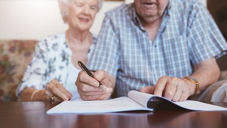 Älteres Ehepaar unterschreibt eine Patientenverfügung.