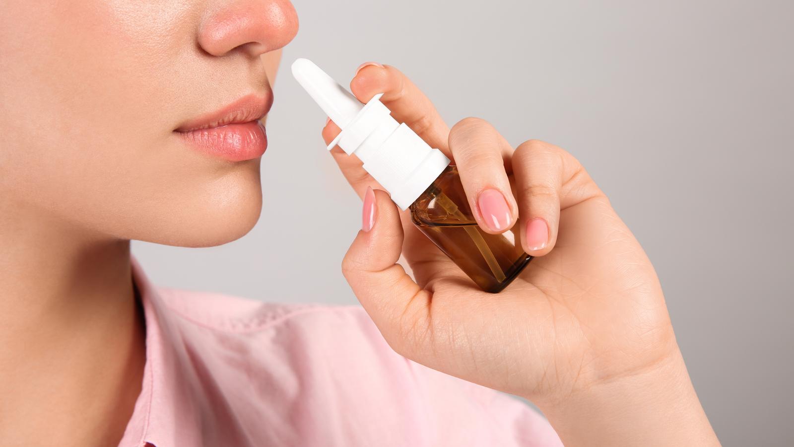 Frau verwendet einen Nasenspray