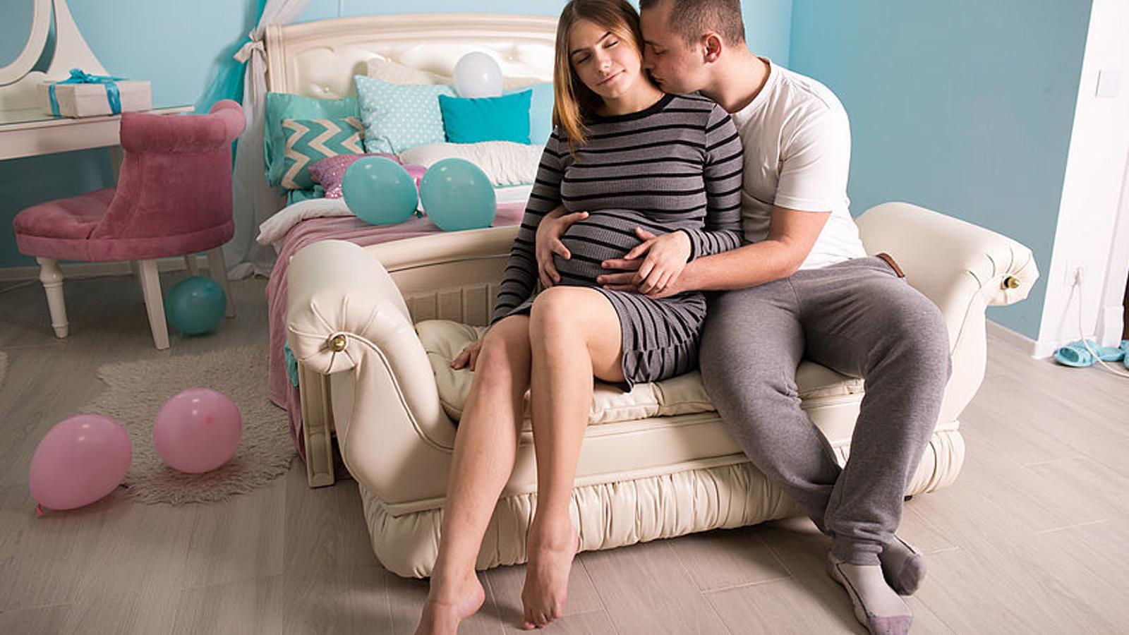 Werdende Eltern sitzen auf der Couch