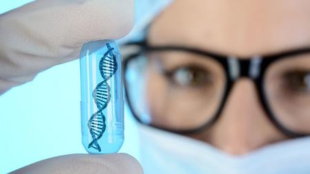Medizinerin hält DNA-Kapsel hoch
