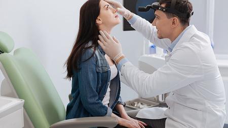 HNO-Arzt untersucht die Nase einer Frau