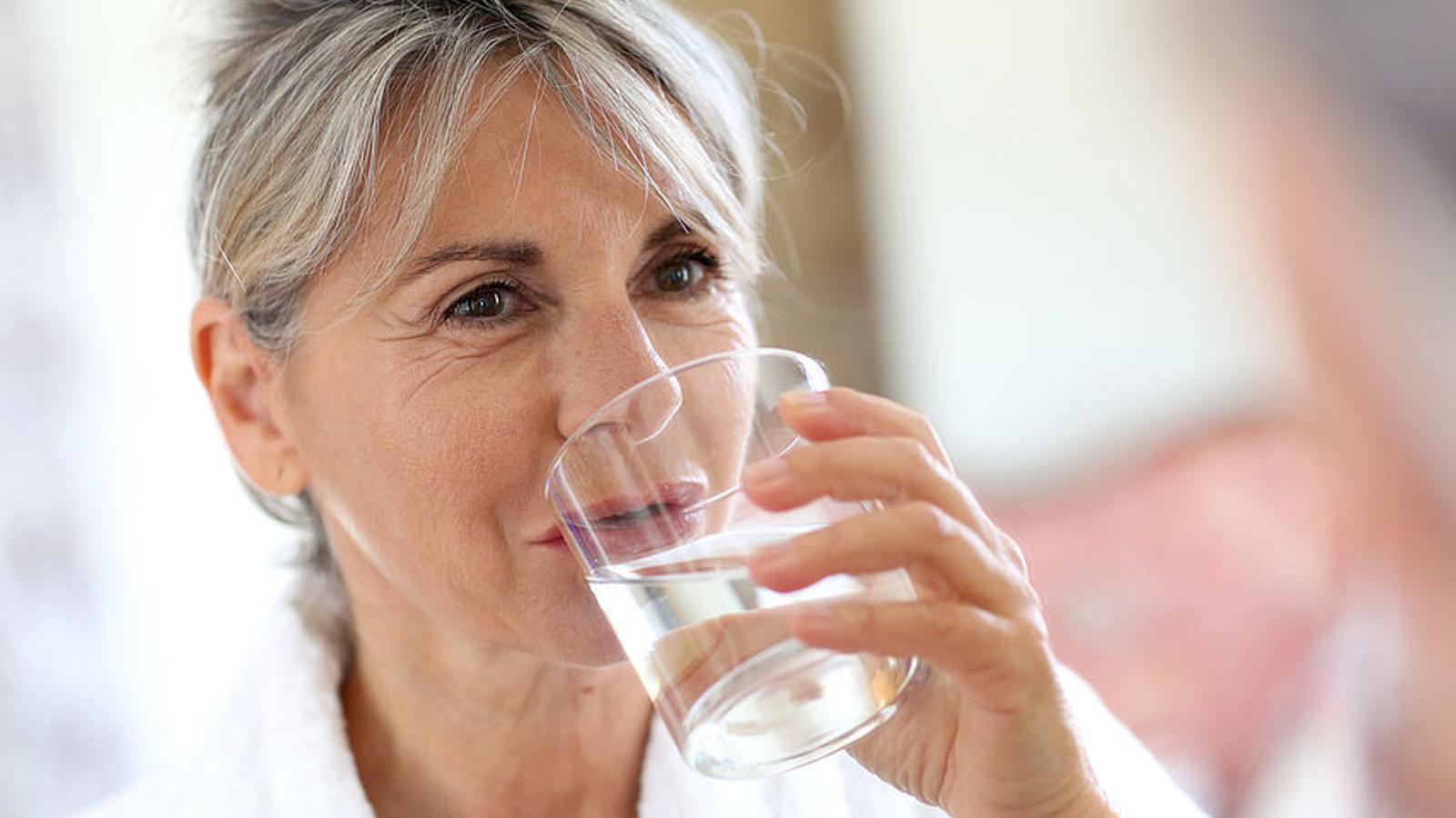 ältere Dame trinkt ein Glas Wasser