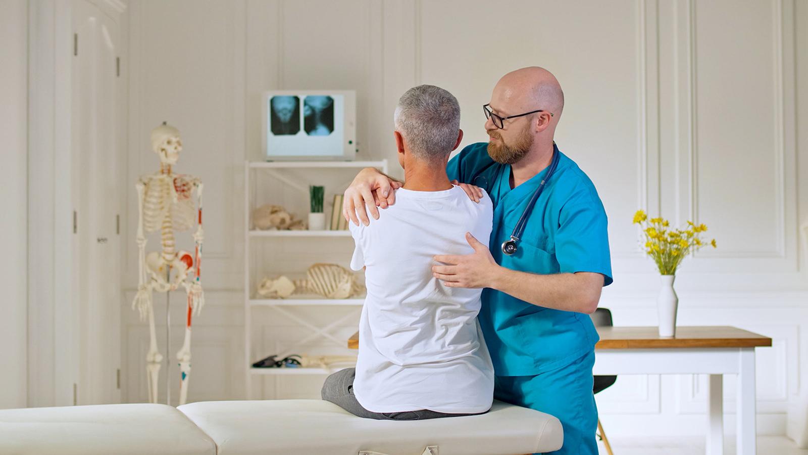 Orthopädie Orthopäde hilft Patientin bei Rückenschmerzen