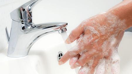 Frau wäscht sich die Hände.