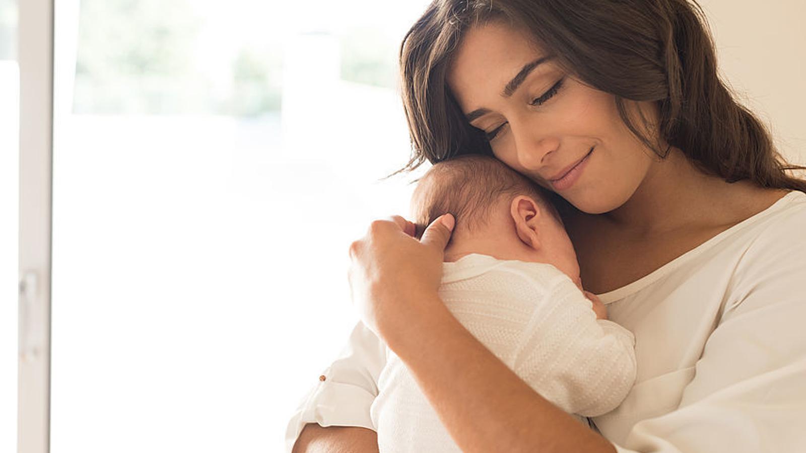 Mutter hält Baby im Arm. 