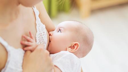 Baby saugt an Brustwarze der stillenden Mutter