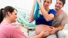 Schwangere testet Geburtspositionen kurz vor der Geburt mit Hebamme