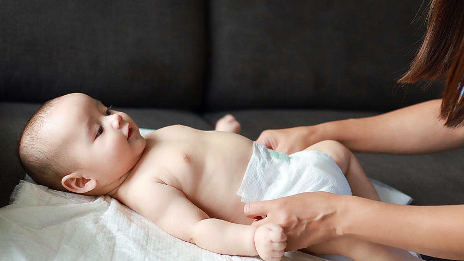 Ein Baby wird gewickelt, hat gerade eine neue Windel bekommen und ist glücklich.