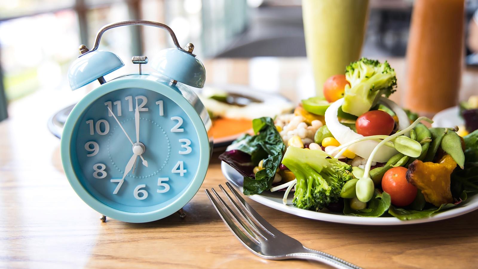 Einen Teller mit Gemüse und daneben ein Wecker